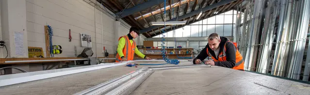 The Mactrac Factory, two people crafting curtain rails at a workbench